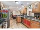 Bright kitchen with stainless steel appliances, wood cabinets, granite countertops, and open access to the living area at 1666 Pine Pl, Clearwater, FL 33755