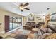 Spacious living room leading to a screened pool area, featuring modern seating and stylish ceiling fans at 1666 Pine Pl, Clearwater, FL 33755