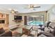 A comfortable living room features a fireplace, a TV, and sliding doors to a screened pool at 1666 Pine Pl, Clearwater, FL 33755