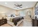 Bedroom features a ceiling fan, hardwood floors, a large bed, and a big window with natural light at 1666 Pine Pl, Clearwater, FL 33755
