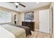 Bedroom showcasing wood floors, a ceiling fan, a big bed, and a large window with natural light at 1666 Pine Pl, Clearwater, FL 33755