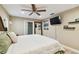Main bedroom with wood floor, ensuite bathroom, ceiling fan, and wall mounted television at 1666 Pine Pl, Clearwater, FL 33755