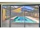 Enclosed screened in pool with shade sails and concrete decking offering a private outdoor oasis at 1666 Pine Pl, Clearwater, FL 33755