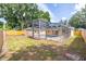 Backyard with pool and yellow house featuring a screened enclosure and wood fence at 1713 W Louisiana Ave, Tampa, FL 33603