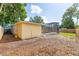Backyard with yellow house, wood fence, and pool with screened enclosure, surrounded by leafy trees at 1713 W Louisiana Ave, Tampa, FL 33603