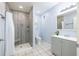 Renovated bathroom featuring a gray vanity, shower, and toilet against a fresh blue backdrop at 1713 W Louisiana Ave, Tampa, FL 33603