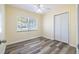 Bright bedroom with modern vinyl flooring, ceiling fan, and double door closet for ample storage at 1713 W Louisiana Ave, Tampa, FL 33603