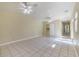 Large empty room with beige tile flooring and two ceiling fans is awaiting your personal touch at 1713 W Louisiana Ave, Tampa, FL 33603