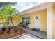 Inviting home exterior featuring palm trees, rocking chairs, a brick border, and a decorative wreath at 1713 W Louisiana Ave, Tampa, FL 33603