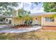 Charming yellow home featuring a welcoming front yard, and covered carport at 1713 W Louisiana Ave, Tampa, FL 33603