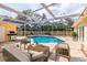 Outdoor pool area with screened enclosure, brick patio, comfortable seating, and grill at 1713 W Louisiana Ave, Tampa, FL 33603