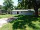A view of the rear of the home, deck, and the expansive, grassy backyard at 17236 Spring Valley Rd, Dade City, FL 33523