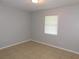 Cozy bedroom with neutral tiled floor, a window that provides natural light, and neutral colored walls at 17236 Spring Valley Rd, Dade City, FL 33523