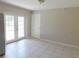 Bright dining room with neutral tiled flooring, white French doors, neutral walls, and a modern light fixture at 17236 Spring Valley Rd, Dade City, FL 33523