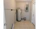 Tiled utility room contains water heater, electrical panel, and storage space at 17236 Spring Valley Rd, Dade City, FL 33523