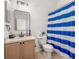 Neutral bathroom featuring striped shower curtain, modern mirror, and wood vanity at 1749 Sedgefield Ct, Odessa, FL 33556