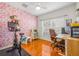 Bedroom featuring a pink accent wall, wood floors, and a work desk at 1749 Sedgefield Ct, Odessa, FL 33556