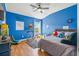 Blue bedroom with wood floors, a gray rug, and a bed at 1749 Sedgefield Ct, Odessa, FL 33556
