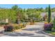 Gated community entrance featuring stone pillars, lush landscaping, and a secure entry system at 1749 Sedgefield Ct, Odessa, FL 33556