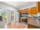 Bright kitchen with stainless steel appliances, wood cabinets, and sliding door to the outside at 1749 Sedgefield Ct, Odessa, FL 33556