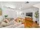 Spacious living room with hardwood floors, a comfy couch, and a large TV for entertainment at 1749 Sedgefield Ct, Odessa, FL 33556