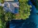 Aerial view of the home's backyard pool and the surrounding mature landscaping and neighboring pond at 1802 Oak Ridge Rd, Safety Harbor, FL 34695
