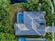 An aerial shot of a tiled roof of Safety Harbor home with a sparkling pool and lush landscaping at 1802 Oak Ridge Rd, Safety Harbor, FL 34695