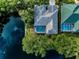 Aerial view of a home with a screened in swimming pool that backs up to a large pond at 1802 Oak Ridge Rd, Safety Harbor, FL 34695