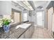Bright bathroom with white cabinets, granite countertops, and arched windows at 1802 Oak Ridge Rd, Safety Harbor, FL 34695