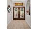 Welcoming entryway featuring double front doors with decorative glass and neutral tile flooring at 1802 Oak Ridge Rd, Safety Harbor, FL 34695