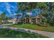 Charming single-story home with lush landscaping, manicured lawn, and a welcoming entrance framed by a palm tree at 1802 Oak Ridge Rd, Safety Harbor, FL 34695