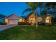 Inviting single-story home featuring lush landscaping, a manicured lawn, and a charming front entrance with double doors at 1802 Oak Ridge Rd, Safety Harbor, FL 34695