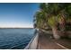 Scenic waterfront path with lush tropical trees and tranquil water views for relaxing strolls at 1802 Oak Ridge Rd, Safety Harbor, FL 34695