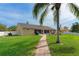 Expansive backyard with lush lawn and brick walkway leading towards the home and a dock at 18816 Tracer Dr, Lutz, FL 33549