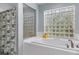 A luxurious bathroom features a soaking tub next to a unique glass block window offering natural light and privacy at 18816 Tracer Dr, Lutz, FL 33549