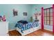 A delightful bedroom with a white trundle bed, dino decor, and colorful accents is a playful retreat at 18816 Tracer Dr, Lutz, FL 33549