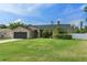 Charming single-story home with a well-manicured lawn, mature landscaping, and an attached two-car garage at 18816 Tracer Dr, Lutz, FL 33549