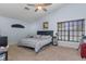Bright bedroom with ceiling fan, large window, and neutral carpet at 18816 Tracer Dr, Lutz, FL 33549