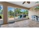 An enclosed patio offers views of the backyard, extending living space with tiled floors, a grill and ceiling fan at 18816 Tracer Dr, Lutz, FL 33549