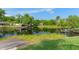 Lush, green waterfront view with a dock and boat lift in calm waters surrounded by trees at 18816 Tracer Dr, Lutz, FL 33549