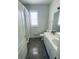 Clean bathroom with a shower/tub combo and simple vanity with a large mirror at 19709 Wyndham Lakes Dr, Odessa, FL 33556