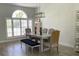 Dining room featuring a rustic table, upholstered chairs, and a blue bench, all lit by modern chandelier at 19709 Wyndham Lakes Dr, Odessa, FL 33556