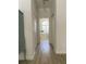 Hallway leading to bathroom, featuring neutral tile floor and natural light at 19709 Wyndham Lakes Dr, Odessa, FL 33556