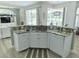 A kitchen island featuring granite countertops and white cabinets overlooks the pool at 19709 Wyndham Lakes Dr, Odessa, FL 33556