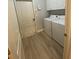 Well-lit laundry room features a washer, dryer, wood-look flooring, and white cabinets for ample storage space at 19709 Wyndham Lakes Dr, Odessa, FL 33556