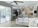 Bright living room with a white couch, opening to a kitchen and a screened-in patio with a pool at 19709 Wyndham Lakes Dr, Odessa, FL 33556
