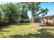 The backyard features mature trees, a metal storage shed, and a grassy area at 2004 Windsor Way, Tampa, FL 33619