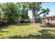 The backyard features mature trees, a metal storage shed, and a grassy area at 2004 Windsor Way, Tampa, FL 33619