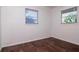 Bedroom featuring wood-look flooring and two windows for natural light at 2004 Windsor Way, Tampa, FL 33619