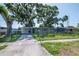 Exterior shot of a single-story home with covered parking and mature trees at 2004 Windsor Way, Tampa, FL 33619